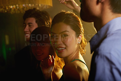 Buy stock photo Shot of a group of young asian people dancing together in a nightclub