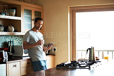 Buy stock photo Cropped shot of a handsome man eating breakfast while using a tablet