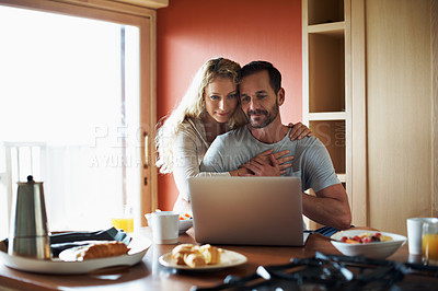 Buy stock photo Cropped shot of a couple using a laptop in the middle of breakfast