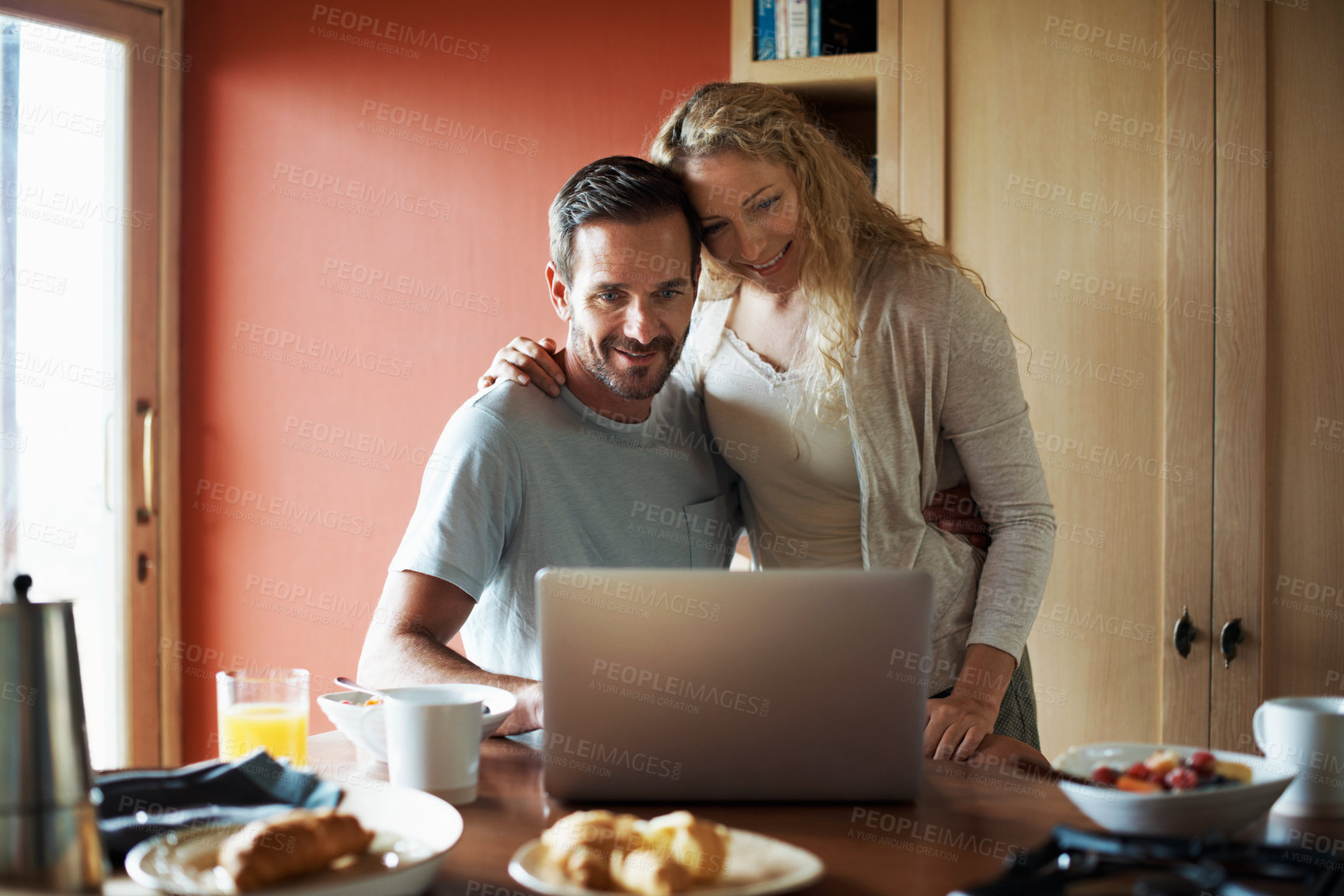 Buy stock photo Kitchen, happy and couple on laptop in morning for website, internet and connection with breakfast. Marriage, home and man with woman for bonding, love and hug on computer for news, email and search