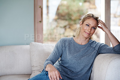 Buy stock photo Cropped portrait of an attractive woman relaxing on her living room sofa