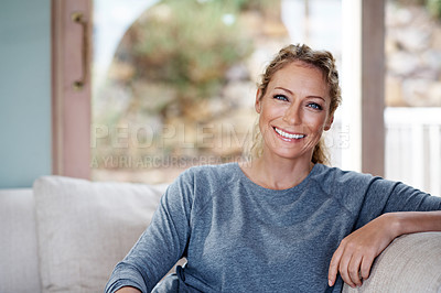 Buy stock photo Cropped portrait of an attractive woman relaxing on her living room sofa