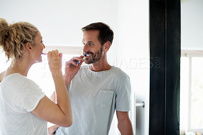 Buy stock photo Cropped shot of a couple brushing their teeth in the bathroom