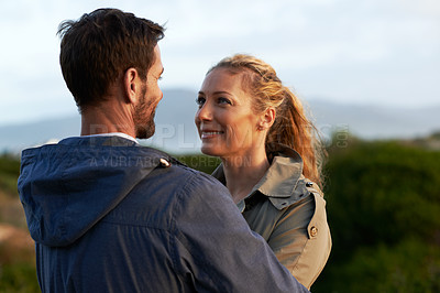 Buy stock photo Cropped shot of an affectionate couple standing face-to-face outdoors