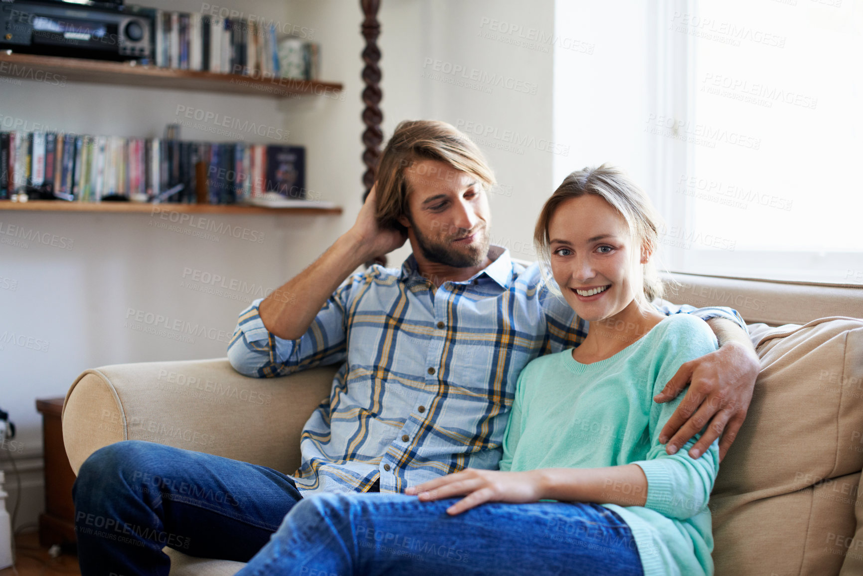 Buy stock photo Shot of a young couple relaxing on a sofa at home