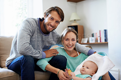 Buy stock photo Portrait of a young couple playing with their baby at home
