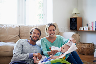 Buy stock photo Portrait of a young couple feeding their baby at home