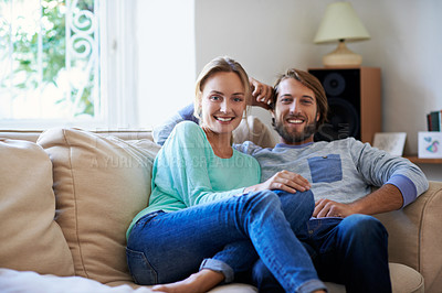 Buy stock photo Pportrait of a young couple relaxing on a sofa at home