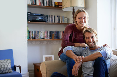 Buy stock photo Portrait of a young couple relaxing on the sofa together at home