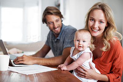 Buy stock photo Portrait of a couple using a laptop while cradling their baby