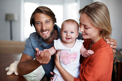Buy stock photo Portrait of a smiling young dad with his wife and their baby girl at home