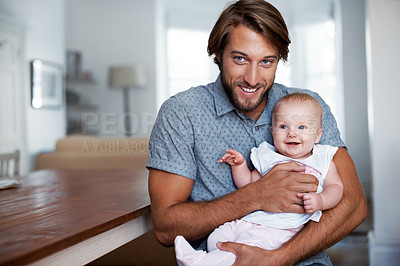 Buy stock photo Portrait of a smiling father holding his baby girl at home