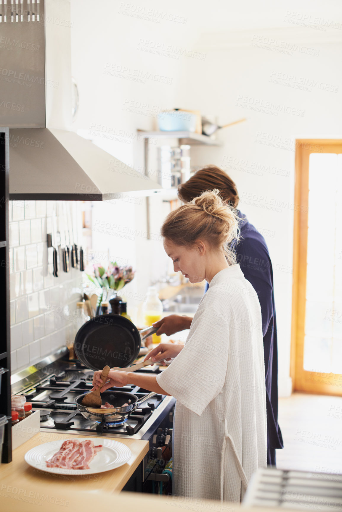 Buy stock photo Shot of a young couple cooking breakfast together in the kitchen