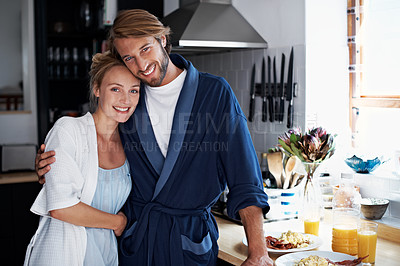 Buy stock photo Portrait of a young couple standing in the kitchen while cooking breakfast