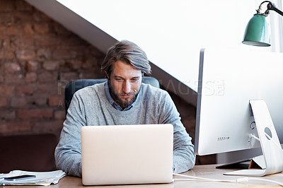 Buy stock photo Shot of a young man working on a laptop in his study at home