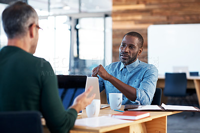 Buy stock photo Cropped shot of two businessman talking over a desk