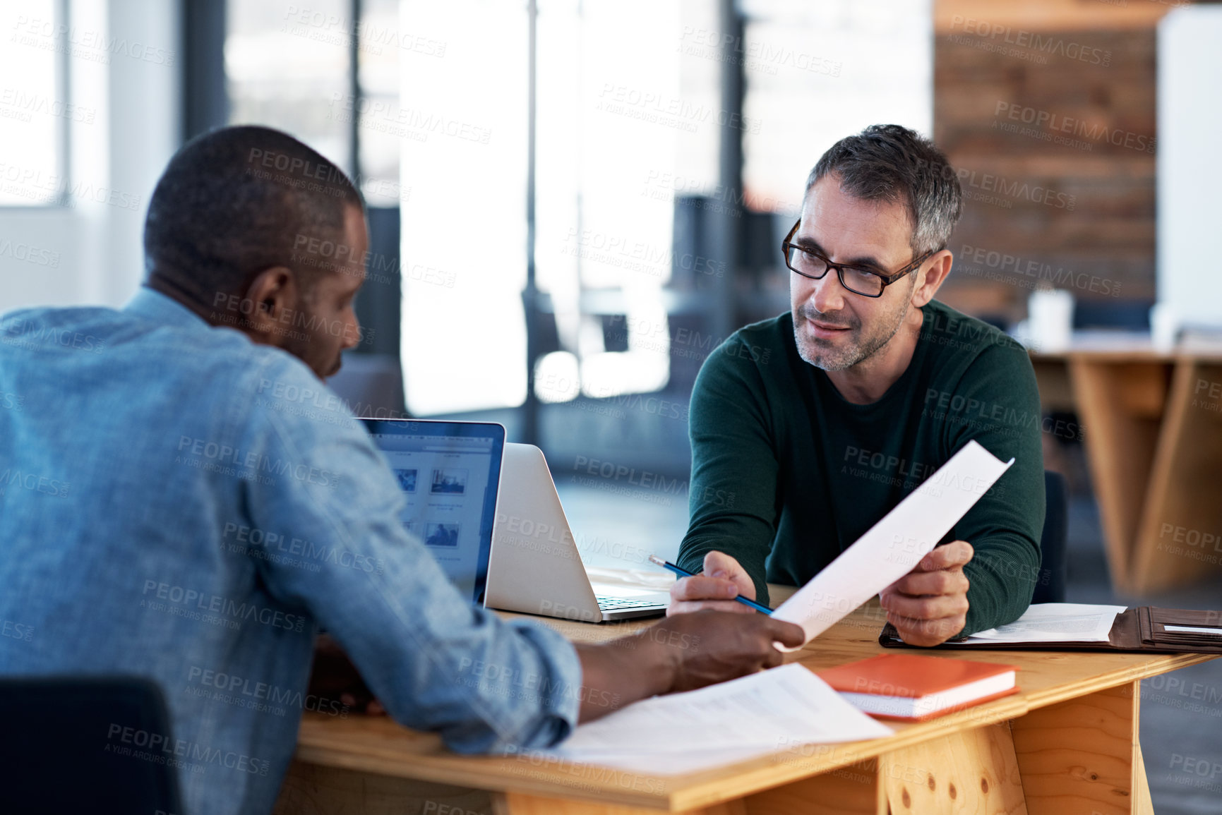 Buy stock photo Cropped shot of two businessman talking over a desk