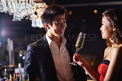 Buy stock photo Shot of a young asian couple drinking in a bar