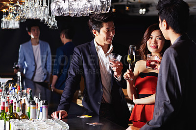 Buy stock photo Shot of a group of friends drinking together in a bar