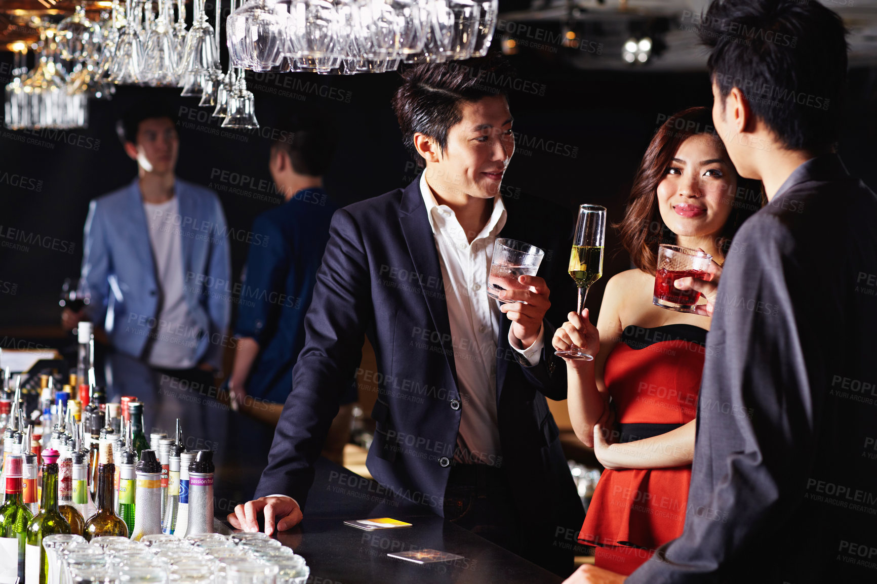 Buy stock photo Shot of a group of friends drinking together in a bar