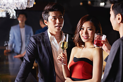 Buy stock photo Portrait of an attractive asian woman drinking with two male friends in a club