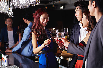 Buy stock photo Shot of a group of friends celebrating with drinks in a nightclub