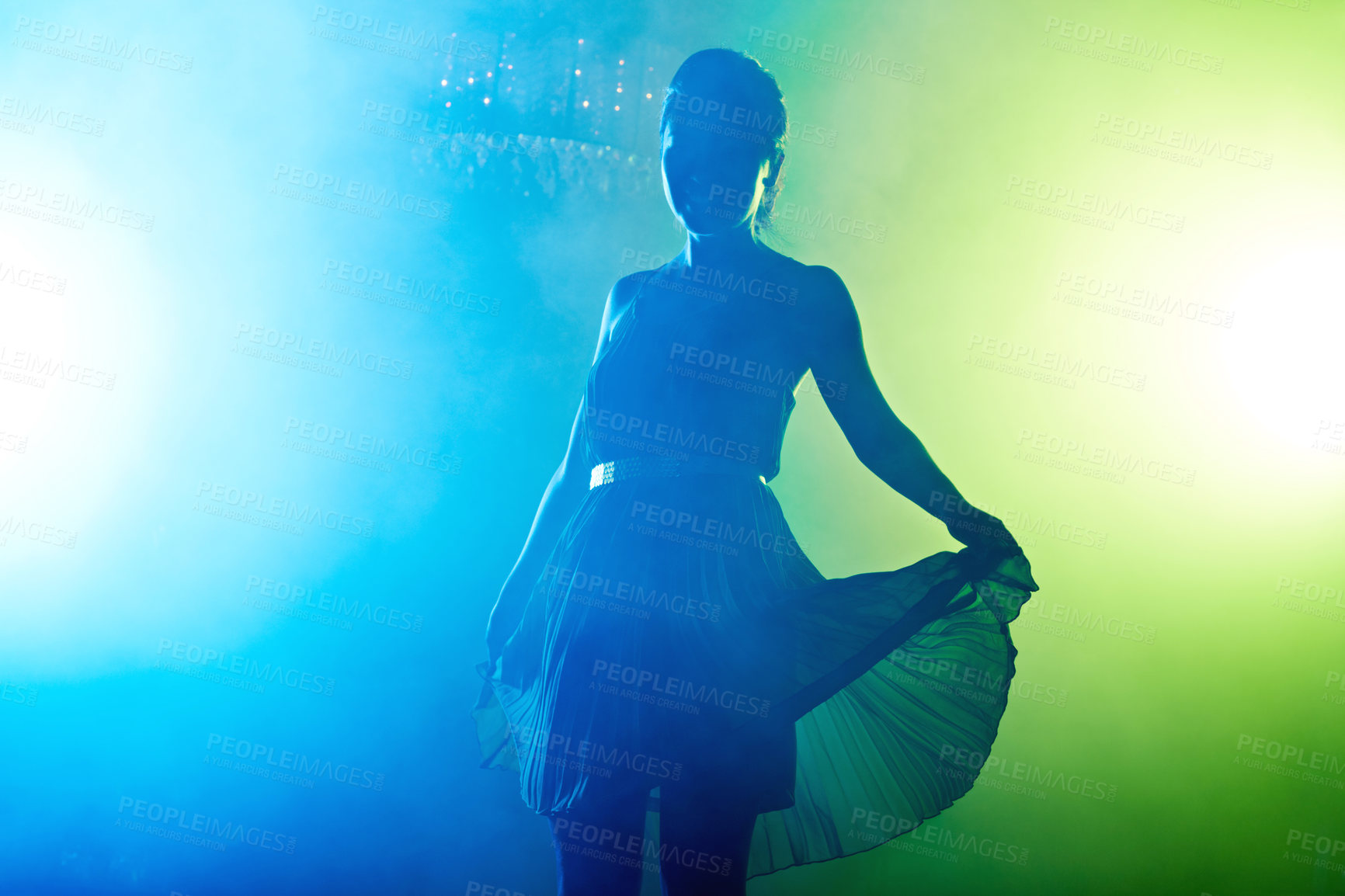 Buy stock photo Shot of an attractive young asian woman silhouetted on the dance floor by nightclub lights