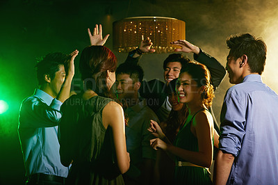 Buy stock photo Shot of a group of young asian people dancing together in a nightclub