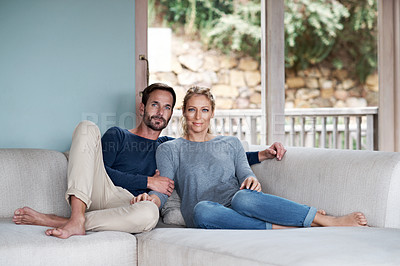 Buy stock photo Shot of a couple relaxing on their living room sofa