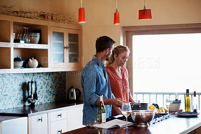 Buy stock photo Shot of a couple having some wine while preparing a meal in the kitchen
