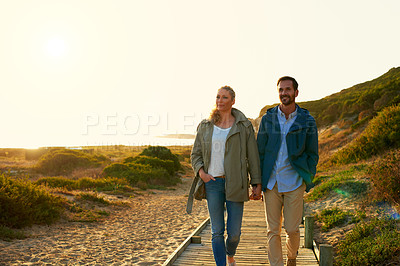 Buy stock photo Shot of an affectionate couple walking outdoors