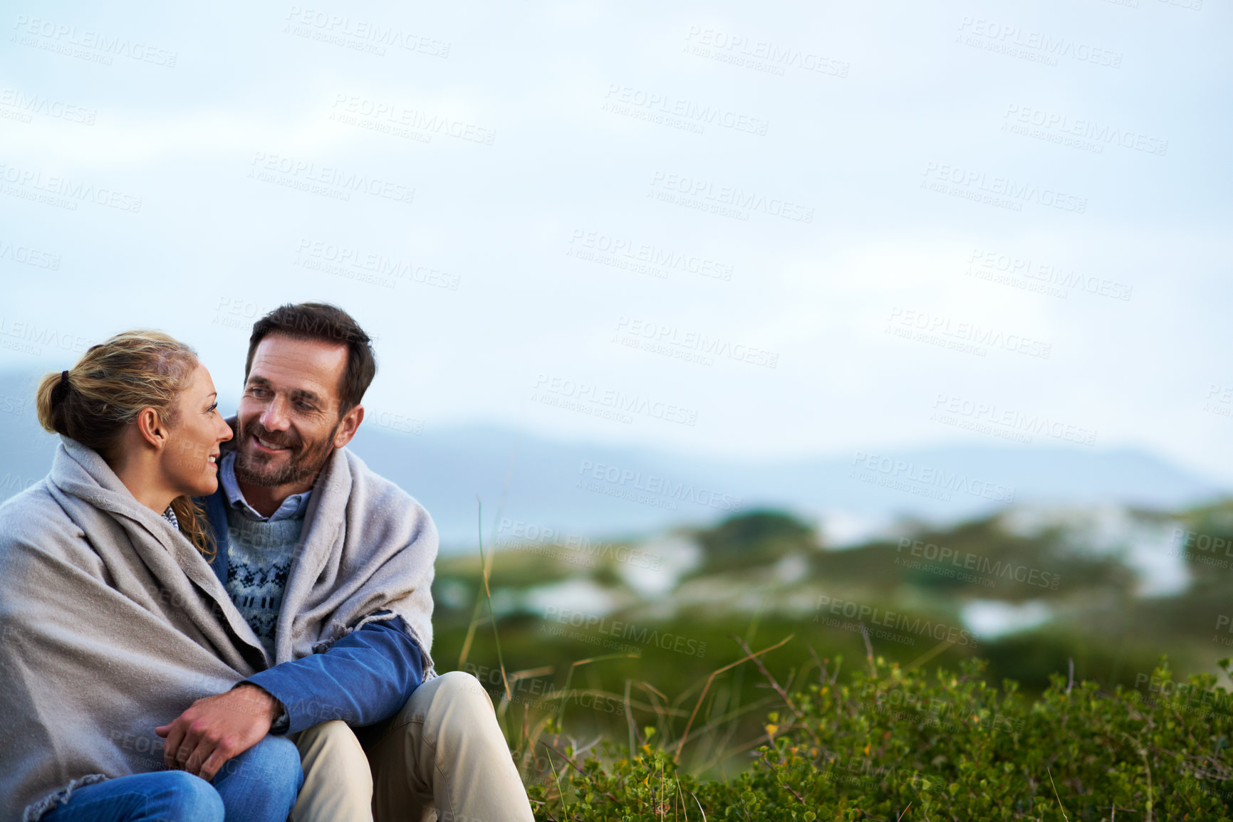 Buy stock photo Travel, happy couple and blanket in nature for bonding, weekend outing or comfort on romantic date. Space, trust and mature people with talk outdoor for cozy getaway, marriage security and warm love