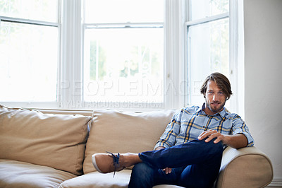 Buy stock photo Portrait of a handsome young man relaxing on the sofa at home