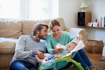 Buy stock photo Shot of a young couple feeding their baby at home