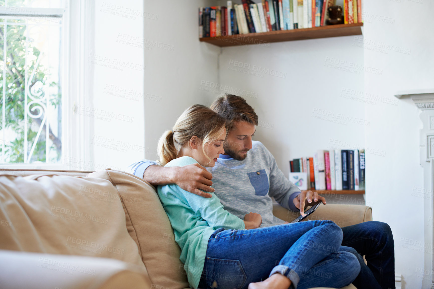 Buy stock photo Couple, relax and scroll in living room with tablet, search online show and love bonding on weekend. People, hug and chill in home with tech, entertainment and browsing website for streaming film.