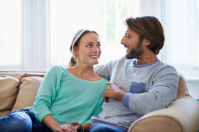 Buy stock photo Shot of a loving young couple relaxing on a sofa at home