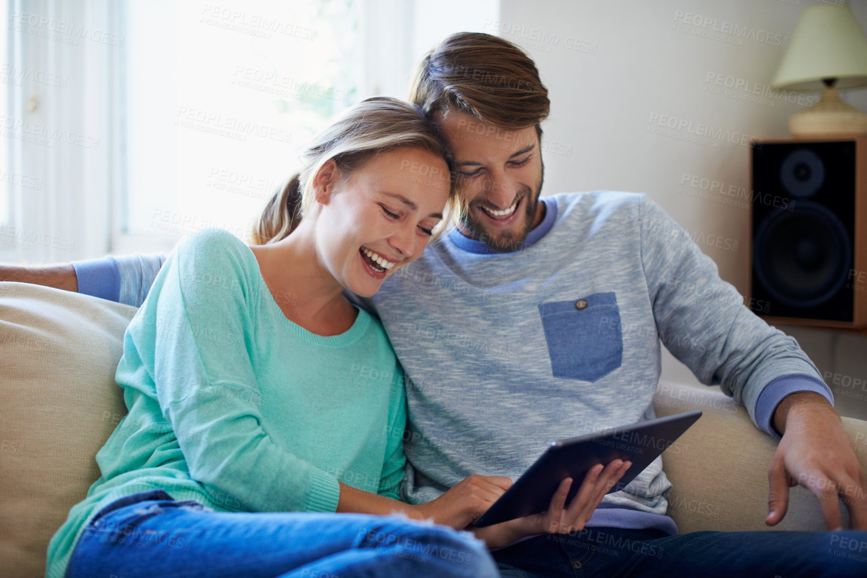 Buy stock photo Couple, rest and laughing with tablet in lounge, online and streaming with app subscription in home. Happy people, bonding and watching comedy with tech, entertainment and relax with partner in house