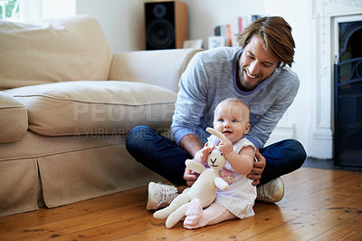 Buy stock photo Shot of a smiling father playing with his baby girl at home