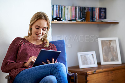 Buy stock photo Shot of a young woman using a digital tablet at home