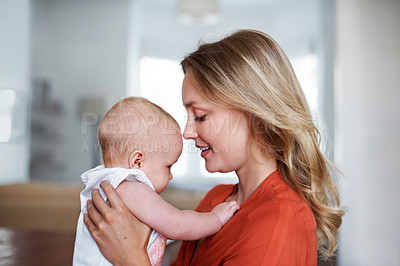 Buy stock photo Shot of a young mother holding her baby at home