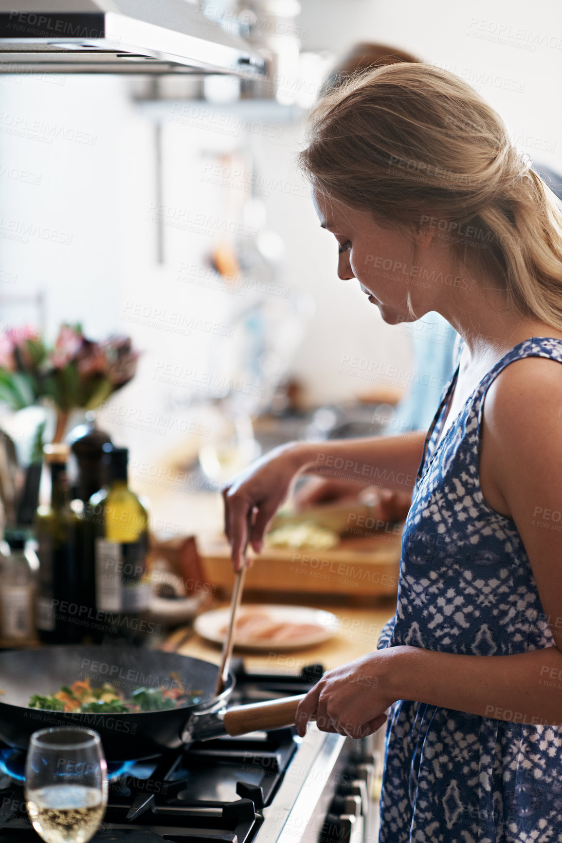 Buy stock photo Woman, stove and cooking in kitchen with partner, meal prep for supper or lunch in home. Female person, mixing ingredients in pan or wok with support for dinner making, recipe and cuisine at house