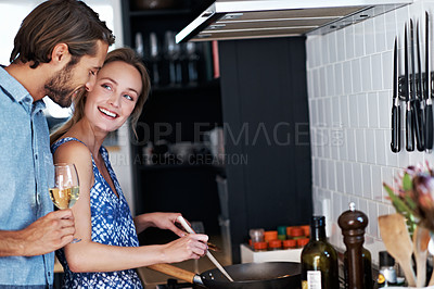 Buy stock photo Shot of a young couple cooking together in the kitchen