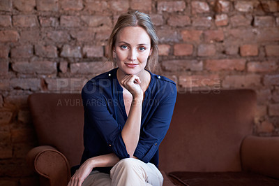 Buy stock photo Portrait of an attractive young woman sitting on the sofa at home