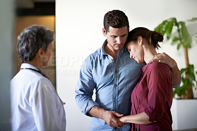 Buy stock photo Shot of a husband comforting his wife in a hospital waiting room