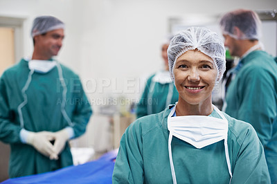 Buy stock photo Portrait of a confident doctor in the operating room with her surgical team in the background