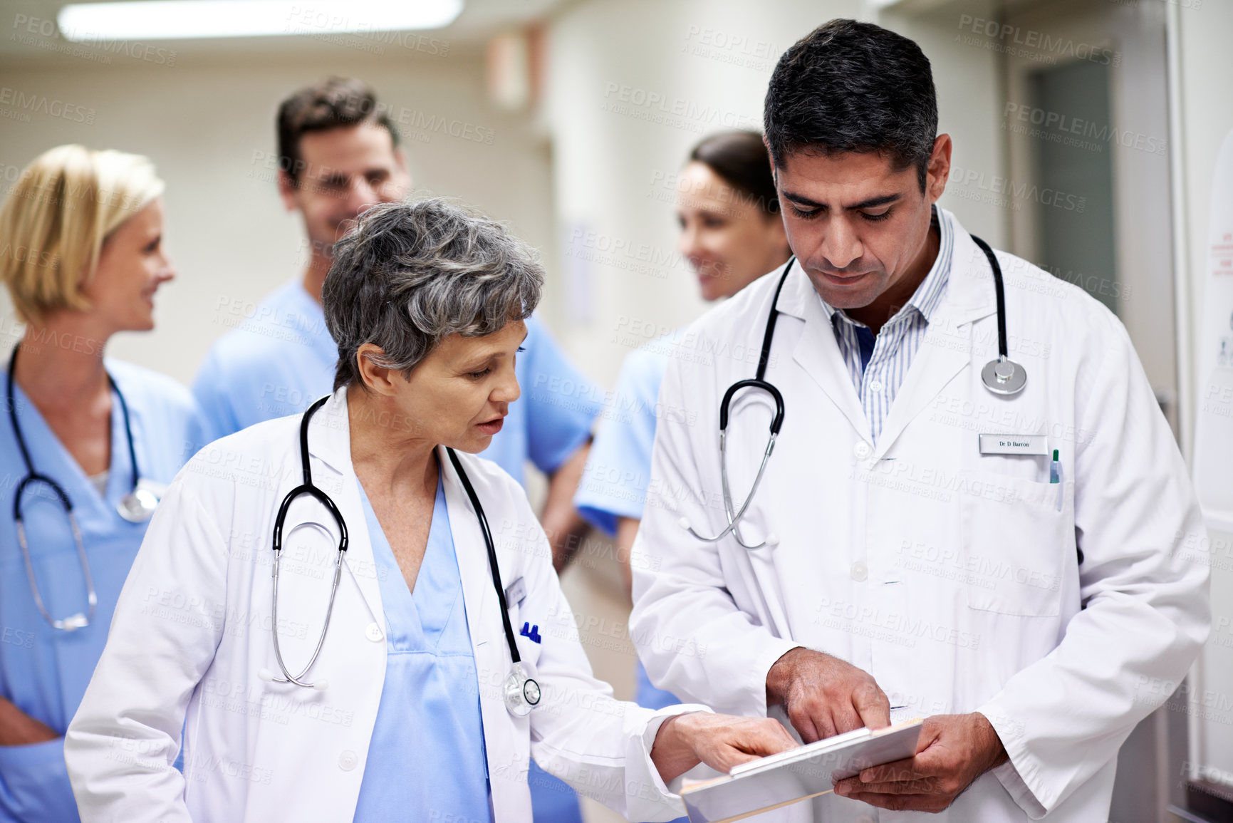 Buy stock photo Doctors, reading and group with paperwork in hallway, help and health services with patient records. Hospital, medical professional and people with clipboard, healthcare and team with treatment plan