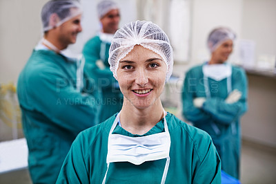 Buy stock photo Portrait of a confident doctor in the operating room with her surgical team in the background