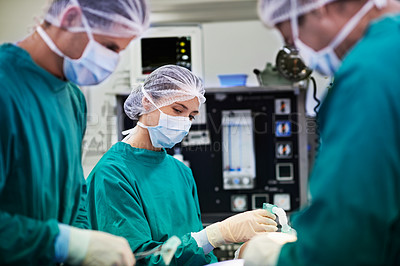 Buy stock photo Shot of a team of surgeons performing an operation