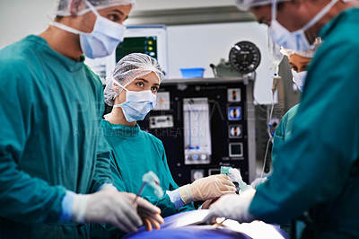 Buy stock photo Shot of a team of surgeons performing an operation