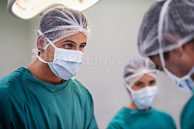Buy stock photo Shot of a team of surgeons performing an operation